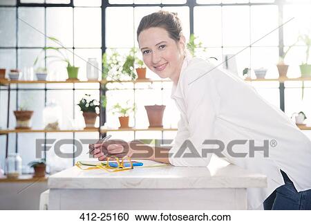 Portrait of young woman leaning on kitchen counter View Large Photo Image Stock Image - Portrait of young woman leaning on kitchen counter. Fotosearch