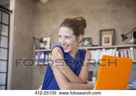 Portrait of young woman with orange laptop sitting in studio View Large Photo Image Stock Photography - Portrait of young woman with orange laptop sitting in studio. Fotosearch