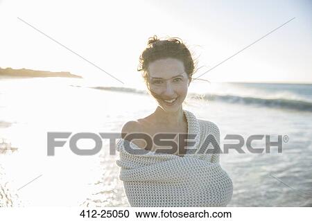 Portrait of young woman wrapped in blanket on beach View Large Photo Image Stock Image - Portrait of young woman wrapped in blanket on beach. Fotosearch