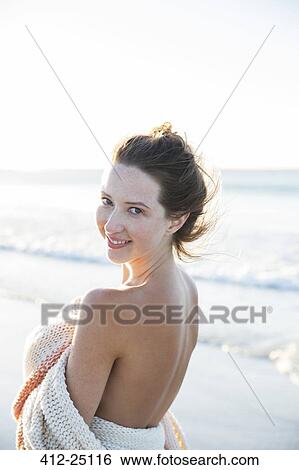 Portrait of young woman wrapped in blanket on beach View Large Photo Image Stock Photograph - Portrait of young woman wrapped in blanket on beach. Fotosearch