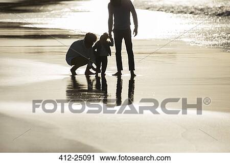 Silhouette of family on beach at sunset View Large Photo Image Stock Image - Silhouette of family on beach at sunset. Fotosearch
