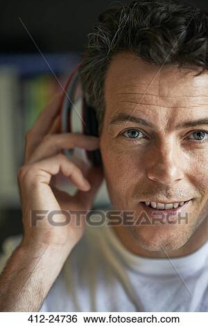 Stock Photograph - "Smiling man with headphones on, close up". Fotosearch