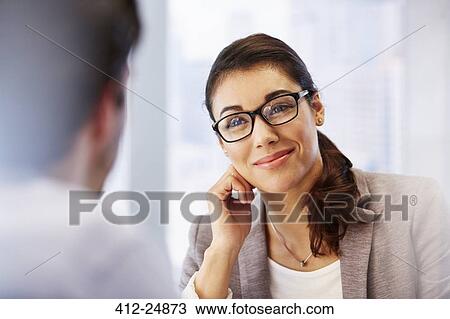 Smiling woman in glasses in office with client View Large Photo Image Stock Image - Smiling woman in glasses in office with client. Fotosearch