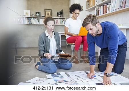 Stock Image - Three young people working together in studio. Fotosearch