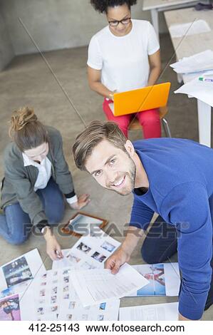 Stock Image - Three young people working together in studio. Fotosearch