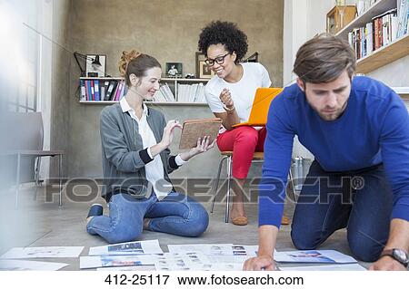 Three young people working together in studio View Large Photo Image Stock Photo - Three young people working together in studio. Fotosearch