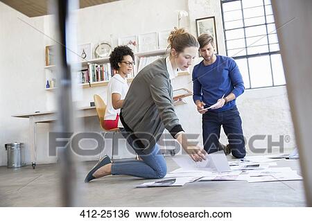 Stock Photograph - Three young people working together in studio. Fotosearch