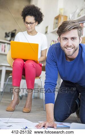 Stock Image - Two young people working together in studio. Fotosearch