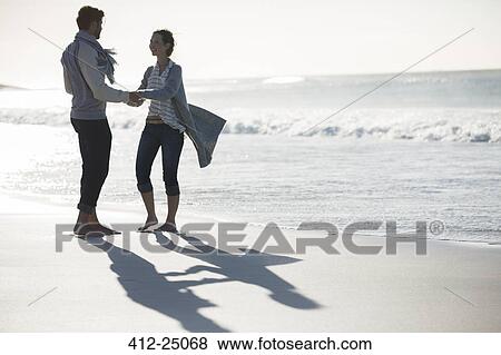 Young couple holding hands on beach View Large Photo Image Stock Photo - Young couple holding hands on beach. Fotosearch