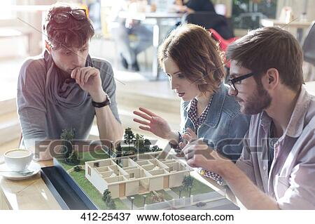 Architects brainstorming at building model in office View Large Photo Image Stock Photo - Architects brainstorming at building model in office. Fotosearch