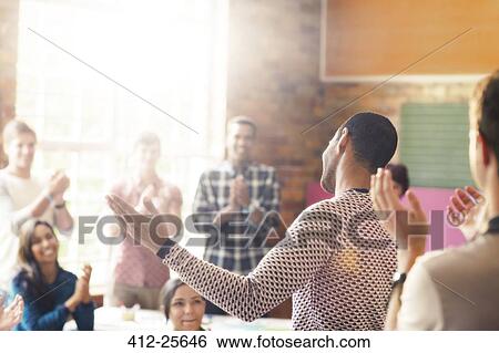 Audience clapping for man with arms outstretched in community center View Large Photo Image Stock Photograph - Audience clapping for man with arms outstretched in community center. Fotosearch