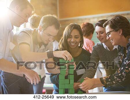 Business people stacking green blocks View Large Photo Image Stock Photo - Business people stacking green blocks. Fotosearch
