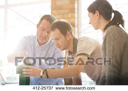 Business people stacking green blocks in sunny office View Large Photo Image Stock Photo - Business people stacking green blocks in sunny office. Fotosearch