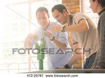 Businessmen balancing green blocks View Large Photo Image Stock Image - Businessmen balancing green blocks. Fotosearch