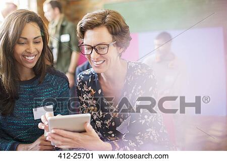 Stock Image - Businesswomen using digital tablet. Fotosearch