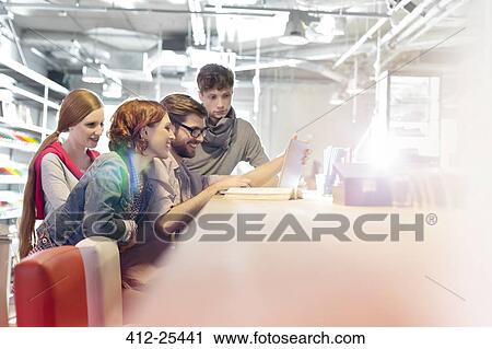 Casual business people meeting at laptop in sunny conference room View Large Photo Image Stock Image - Casual business people meeting at laptop in sunny conference room. Fotosearch