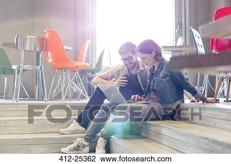 Casual business people using laptop on steps View Large Photo Image Stock Image - Casual business people using laptop on steps. Fotosearch