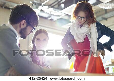 Casual business people working in sunny office View Large Photo Image Picture - Casual business people working in sunny office. Fotosearch