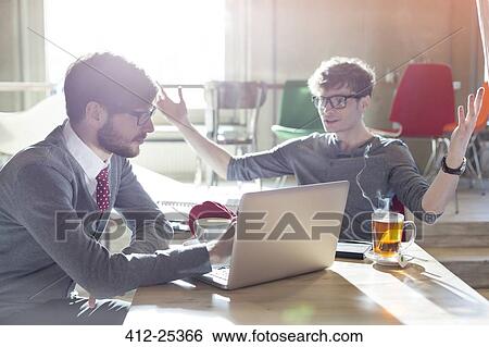 Casual businessmen using laptop in cafe View Large Photo Image Stock Photograph - Casual businessmen using laptop in cafe. Fotosearch
