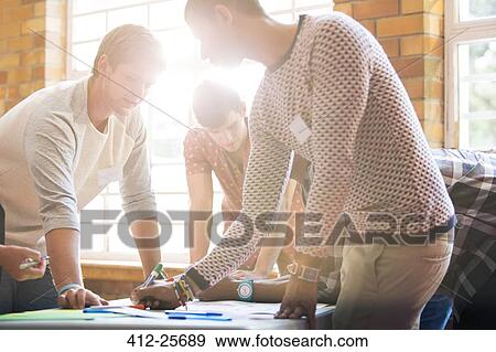 Creative business people writing at table View Large Photo Image Stock Photo - Creative business people writing at table. Fotosearch