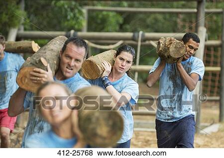 Determined team carrying logs on boot camp race course View Large Photo Image Stock Photo - Determined team carrying logs on boot camp race course. Fotosearch