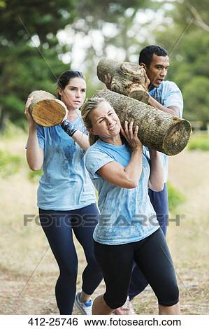 Determined woman running with log on boot camp obstacle course View Large Photo Image Stock Photograph - Determined woman running with log on boot camp obstacle course. Fotosearch
