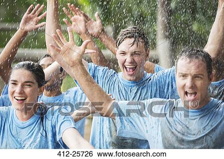 Enthusiastic team cheering in rain at boot camp View Large Photo Image Stock Photograph - Enthusiastic team cheering in rain at boot camp. Fotosearch