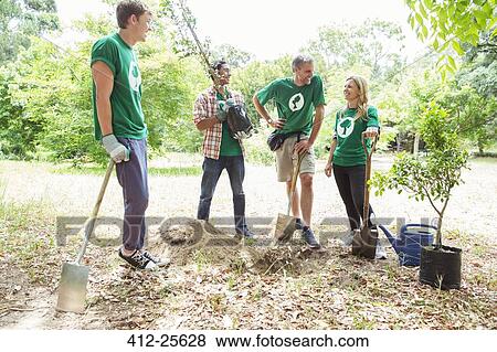 Stock Photo - Environmentalist volunteers planting new tree. Fotosearch