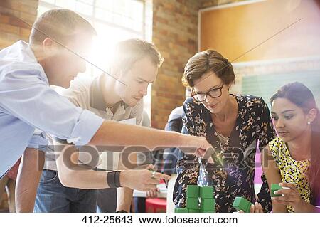 Focused business people stacking green blocks View Large Photo Image Stock Image - Focused business people stacking green blocks. Fotosearch