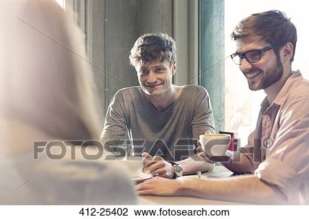 Friends talking and drinking coffee in cafe View Large Photo Image Stock Image - Friends talking and drinking coffee in cafe. Fotosearch