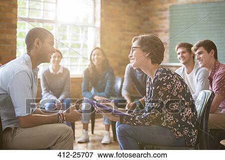 Group watching man and woman talking in group therapy session View Large Photo Image Stock Photo - Group watching man and woman talking in group therapy session. Fotosearch