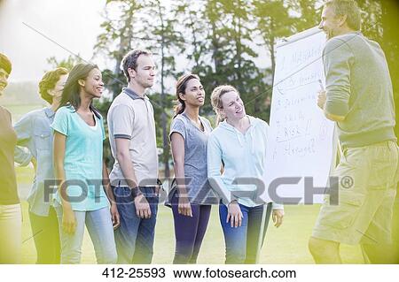 Man leading meeting at flipchart in field View Large Photo Image Stock Image - Man leading meeting at flipchart in field. Fotosearch