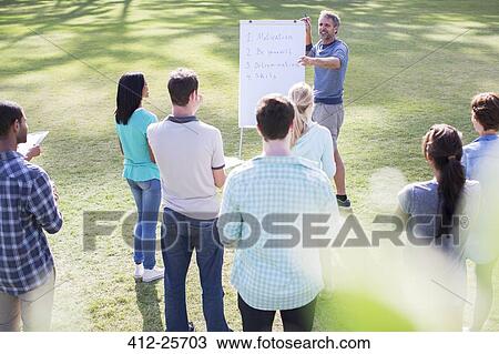 Man leading meeting at flipchart in field View Large Photo Image Stock Image - Man leading meeting at flipchart in field. Fotosearch