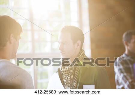 Men talking in sunny community center View Large Photo Image Stock Photo - Men talking in sunny community center. Fotosearch