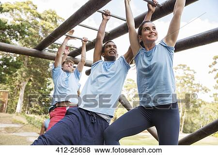 People crossing monkey bars on boot camp obstacle course View Large Photo Image Stock Photo - People crossing monkey bars on boot camp obstacle course. Fotosearch