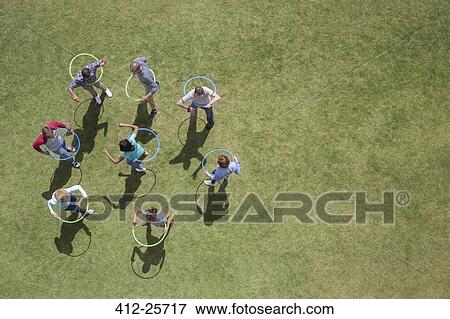 People spinning in plastic hoops in sunny grass View Large Photo Image Stock Photo - People spinning in plastic hoops in sunny grass. Fotosearch