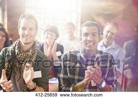 Stock Photo - Portrait of smiling audience clapping. Fotosearch