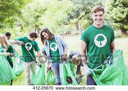 Portrait of smiling environmentalist volunteer picking up trash View Large Photo Image Stock Image - Portrait of smiling environmentalist volunteer picking up trash. Fotosearch