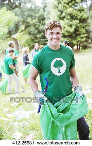 Portrait of smiling environmentalist volunteer picking up trash View Large Photo Image Stock Image - Portrait of smiling environmentalist volunteer picking up trash. Fotosearch