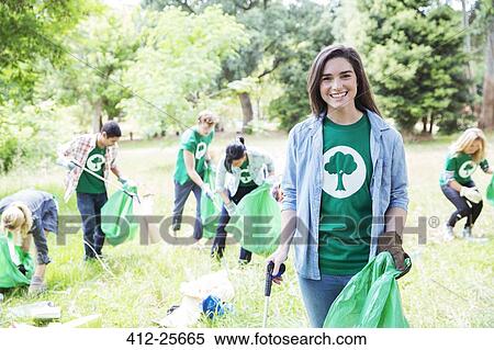Portrait of smiling environmentalist volunteer picking up trash View Large Photo Image Stock Photography - Portrait of smiling environmentalist volunteer picking up trash. Fotosearch