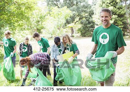 Portrait of smiling environmentalist volunteer picking up trash View Large Photo Image Stock Photography - Portrait of smiling environmentalist volunteer picking up trash. Fotosearch