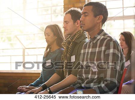 Stock Photography - Serene people with eyes closed in audience. Fotosearch
