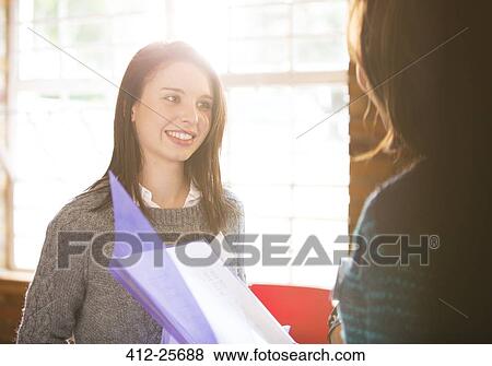 Smiling businesswomen with paperwork in meeting View Large Photo Image Stock Photo - Smiling businesswomen with paperwork in meeting. Fotosearch