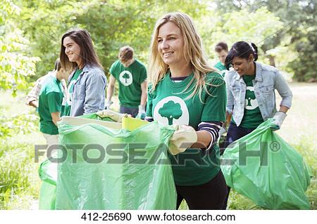 Smiling environmentalist volunteer picking up trash View Large Photo Image Stock Image - Smiling environmentalist volunteer picking up trash. Fotosearch