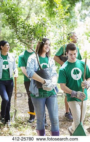 Smiling environmentalist volunteers planting new tree View Large Photo Image Stock Image - Smiling environmentalist volunteers planting new tree. Fotosearch