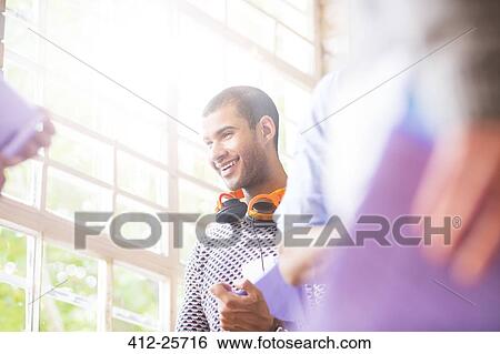 Smiling man talking in meeting View Large Photo Image Stock Photograph - Smiling man talking in meeting. Fotosearch