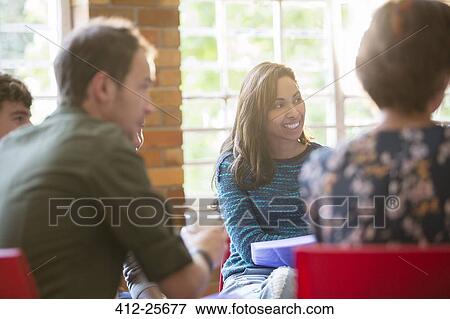 Stock Photo - Smiling woman listening in group therapy session. Fotosearch