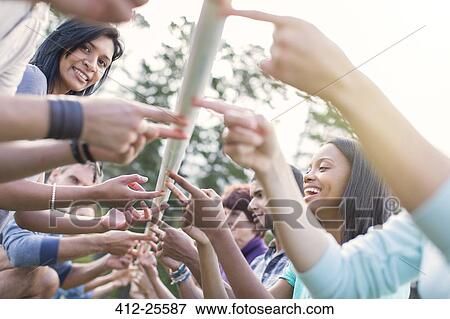 Team balancing pole on fingertips View Large Photo Image Stock Photo - Team balancing pole on fingertips. Fotosearch