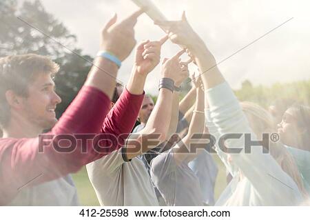Team balancing pole overhead with fingertips View Large Photo Image Stock Photo - Team balancing pole overhead with fingertips. Fotosearch