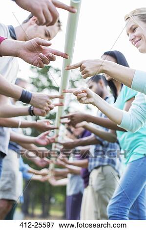 Stock Photo - Team balancing pole with fingertips. Fotosearch